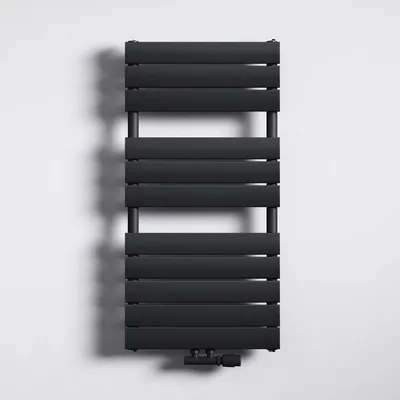 A black radiator is mounted on a white wall.