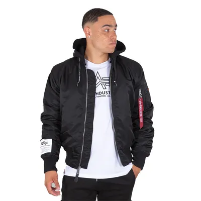 A man wearing a black bomber jacket over a white t-shirt.