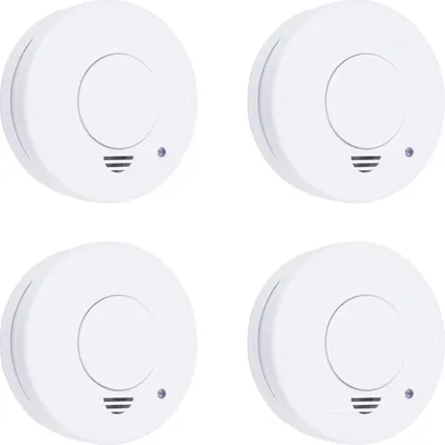 Four white smoke detectors are arranged in a grid on a white background.