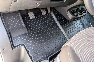 The interior of a vehicle showing custom-fit rubber floor mats.