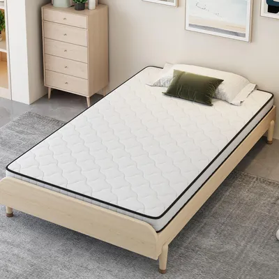 A mattress on a wooden bed frame in a room.