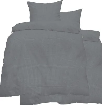 A set of folded grey bedding, including a duvet cover and pillowcases, is displayed against a white background.