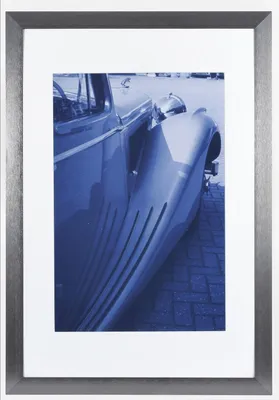 A framed photograph of a vintage car.