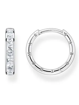 A pair of silver hoop earrings with clear square-cut stones and engraved lettering on one earring, presented against a white background.