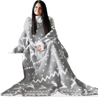 A woman is sitting and wrapped in a blanket with sleeves.