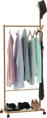 A bamboo garment rack with clothes, shoes, and an umbrella.