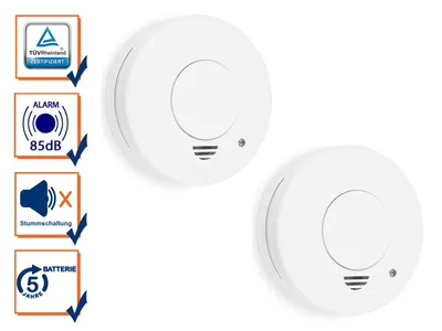Two white smoke detectors are shown against a white background, with a series of icons and text on the left side of the image highlighting product features.