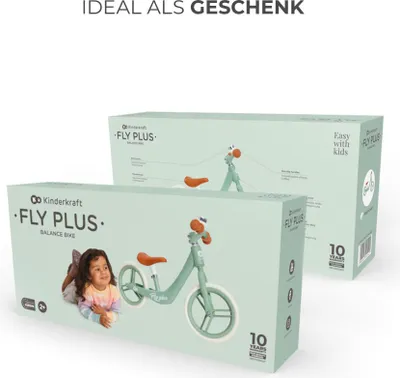 Two boxes of Kinderkraft FLY PLUS balance bikes are shown, one in the foreground and one in the background. A child is lying next to the foreground box.