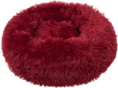 A round, plush dog bed in a burgundy color.