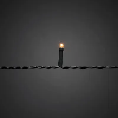 A single LED light on a black wire against a dark gray background.