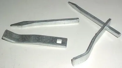 Four metal tools are arranged on a white surface.