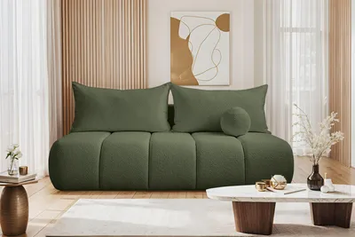 A modern living room scene featuring a green sofa, coffee table, and artwork.