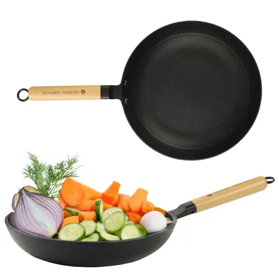 A frying pan with a wooden handle is shown above a close-up of chopped vegetables in a pan.