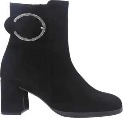 A black ankle boot with a decorative buckle.