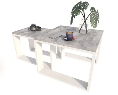 A modern coffee table with a concrete-look top and white frame, featuring a cup of coffee, headphones, and a plant.