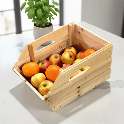 A wooden crate filled with apples and oranges on a countertop, with a potted plant in the background.
