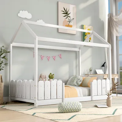 A child's bedroom with a white house-shaped bed, toys, and artwork on the wall.