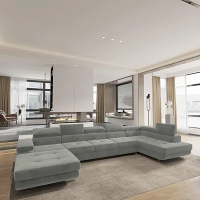 A modern living room with a large sectional sofa in the foreground and a fireplace and windows in the background.
