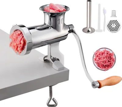 A manual meat grinder with accessories is displayed on a white surface, clamped to a table edge.