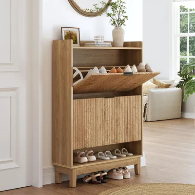 A wooden shoe cabinet with open drawers and shoes inside, placed in a hallway next to a door and a window.
