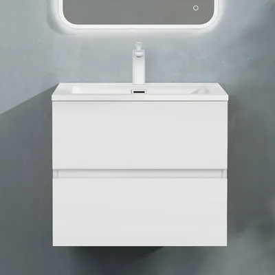 A white bathroom vanity with a sink and faucet against a gray textured wall.