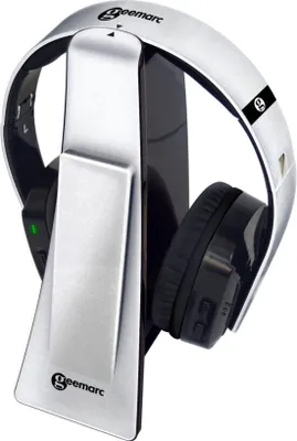 A pair of silver and black wireless headphones resting on their charging stand.