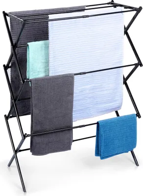A black metal drying rack with several towels draped over it.