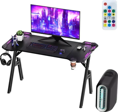 A gaming desk setup with a monitor, keyboard, mouse, headphones, and accessories, presented on a white background.
