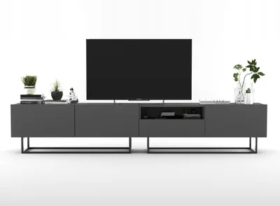 A modern TV stand with a large television on top and decorative items on the side.