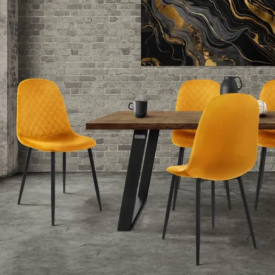 A dining room scene with a wooden table and four yellow velvet chairs.