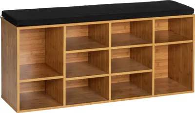 A shoe rack with a black cushion on top, made of light brown wood.
