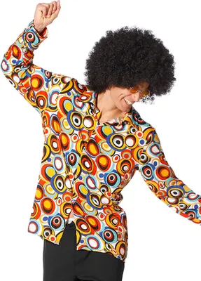 A man wearing a colorful 70s-style shirt and an afro wig is dancing.