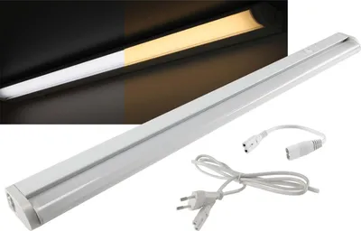 A white LED under-cabinet light fixture with its power cord and adapter.