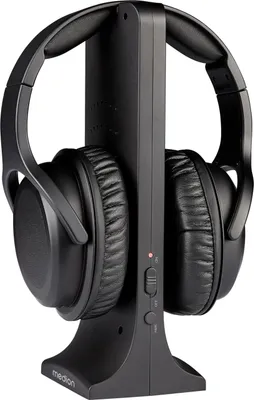 A pair of black over-ear headphones resting on a black charging stand.