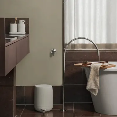 A modern bathroom setting with a bathtub, faucet, and vanity.