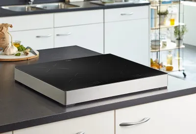 A modern kitchen countertop with a sleek induction cooktop.