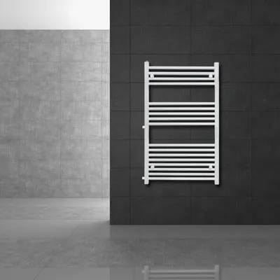 A white towel radiator is mounted on a dark tiled wall in a modern bathroom setting.
