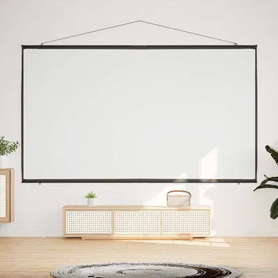 A white projection screen is mounted on a white wall above a light wood media console. The media console has a woven front and a small potted plant on top. A round rug is on the wooden floor in front of the console.
