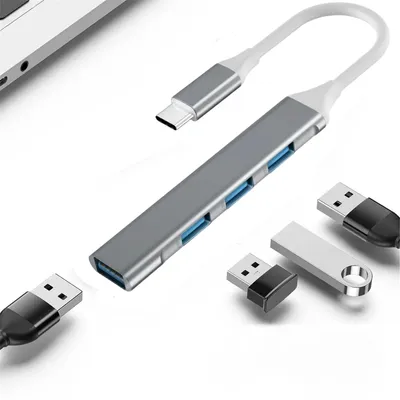 A USB C hub with multiple USB ports and connected USB devices, placed on a white background.