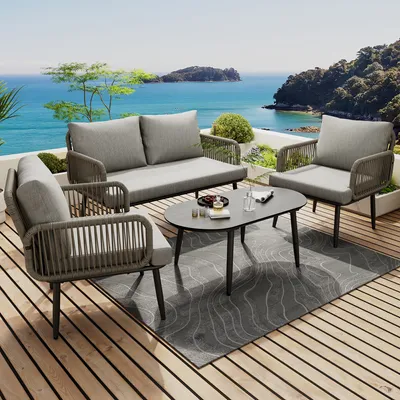 A patio set on a wooden deck overlooking the ocean.