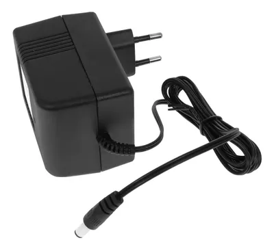 A black power adapter with a European plug and a coiled cable with a barrel connector.