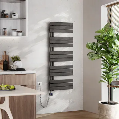 A modern kitchen setting with a radiator, cabinets, and a plant.