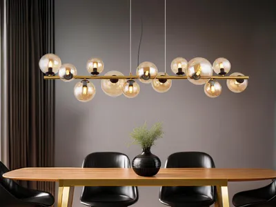 A modern dining room with a wooden table and chairs, illuminated by a multi-bulb pendant light.