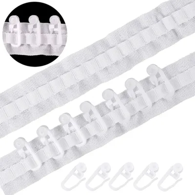 A close-up view of white curtain tape with plastic hooks attached.