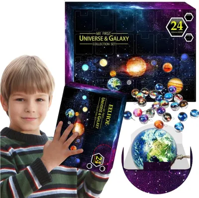 A young boy is holding a box that is part of a universe and galaxy collection set. Scattered around the box are small, round ornaments that appear to be planets. A larger globe of Earth is also visible.