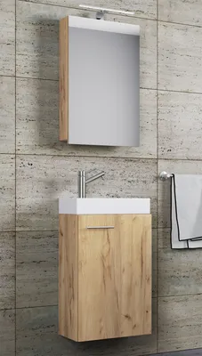 A modern bathroom vanity with a mirror and faucet against a tiled wall.