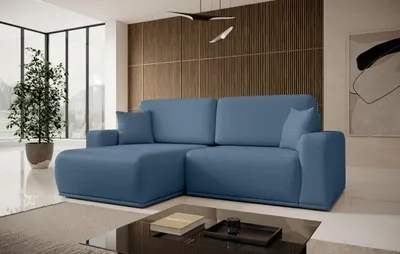 A modern living room with a blue sectional sofa, a large window, and a wooden accent wall.