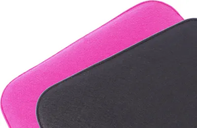 A close-up view of two seat cushions, one black and one pink, layered on top of each other.