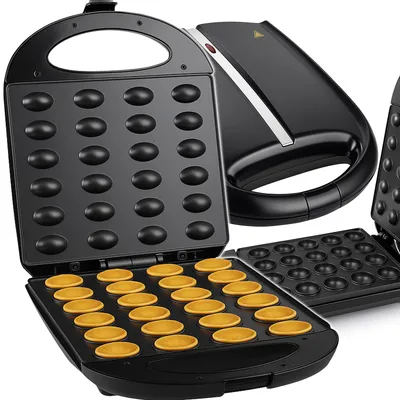 An open waffle maker with 24 indentations, some of which contain cooked waffle batter.