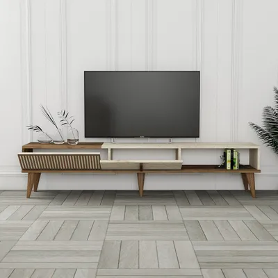 A modern TV stand with a television on top, set against a white paneled wall and a light wood-look floor.